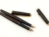 trois types différents de stylos à plume posés sur une surface blanche