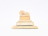 a statue of a lion on top of a pile of books