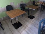 tables and chairs in a room with green walls and wood flooring