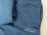 a close up of a pair of blue sweatpants with the logo on them