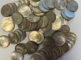 une pile de pièces de monnaie posée sur une table à côté d'un téléphone portable