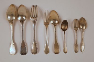 cinq cuillères en argent et six cuillères en argent sur un fond blanc