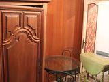 a cabinet and table in a room with wood paneling on the walls