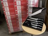 une boîte de couteaux posée sur une table, à côté d'une pile de boîtes