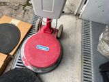 a red machine that is sitting on the sidewalk