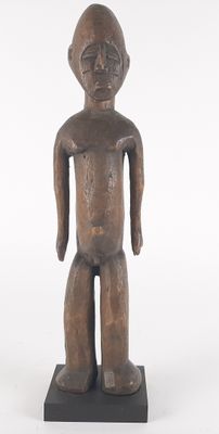 an old wooden statue of a man standing on a black base
