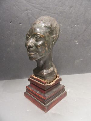 statue of a man ' s head on a wooden base