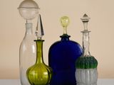 three different colored glass bottles sitting on a table