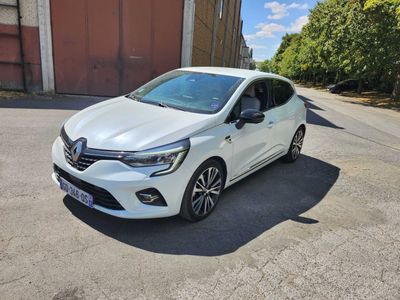 une voiture blanche garée sur le bord de la route, près d'un immeuble