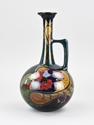 un vase vert orné d'un motif sur fond blanc