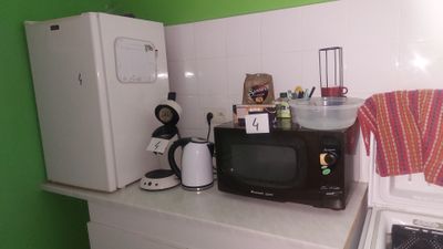 une cuisine équipée d'un micro-ondes, d'un réfrigérateur, d'un four à micro-ondes et d'un grille-pain