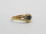 a yellow gold ring with a blue sapphire and two diamonds