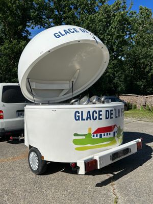 a small ice cream cart with a large ice cream container on the back