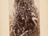 an old black and white photo of a man kneeling in the grass