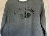 a grey sweatshirt with a black print on the front and a black logo on the back