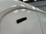 a close up of a white car with a sticker on it