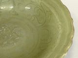 a green bowl sitting on a table with a white background