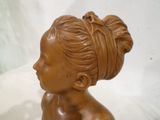 une statue en bronze représentant une femme coiffée d'un chignon
