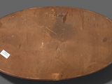 a wooden plate with a metal handle on a gray surface