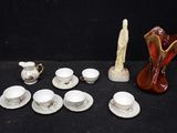 many cups and saucers and a vase on the table