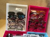 several pairs of glasses are in a pink box with a price tag