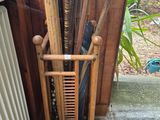 un porte-parapluies en bois sur lequel sont posés des parapluies et d'autres objets