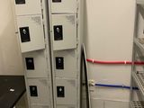 four metal lockers in a room with a black table