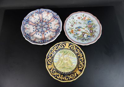 trois assiettes ornées de motifs, posées sur une surface noire