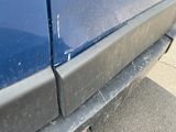 a close up of a blue truck with a broken front bumper