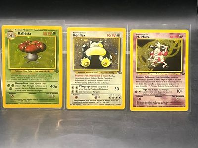 Quatre cartes Pokémon sont alignées en rangée sur une table