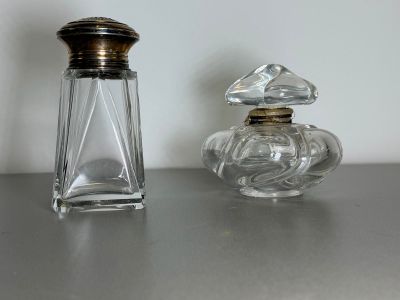 two bottles of perfume sitting on a table next to each other