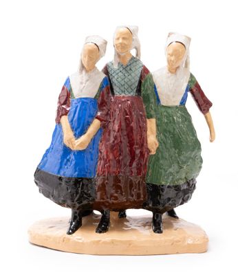 three figurines of women standing on a wooden base