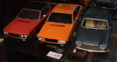 Plusieurs petites voitures sont exposées dans une vitrine.