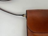 a small brown bag with a strap hanging from it
