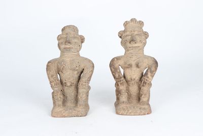 pair of ancient figurines of a man and a woman on a white background