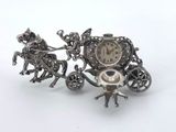 a silver clock sitting on top of a carriage
