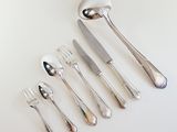 five forks, a spoon, and a knife on the table
