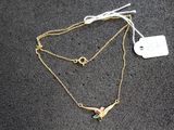 Gros plan sur un collier orné d'un oiseau