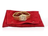 an image of a gold wrist watch on a red velvet bag