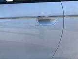 the door handle of a silver car with a hole in it
