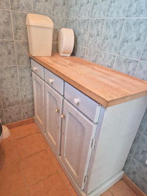 a bathroom with a toilet, sink, and cabinets in it