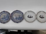 four blue and white plates are lined up on a counter