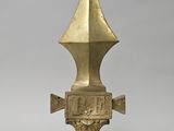une image représentant un objet métallique doré orné d'une croix