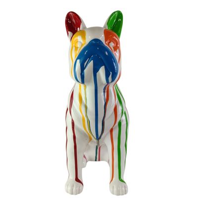 une figurine de chien aux couleurs vives posée sur une surface blanche