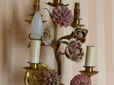 a wall sconce with flowers and candles on it