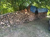 un tas de bois à côté d'une voiture dans la cour