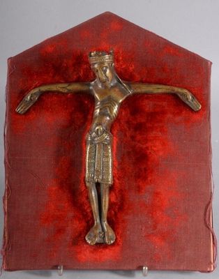 a metal crucifid on a red cloth