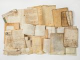 several old papers are stacked on top of each other on a white surface