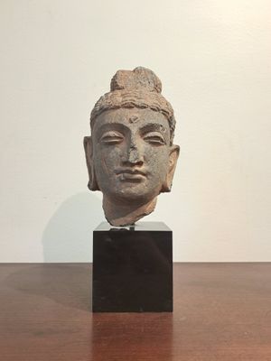 sculpture of a head of a person on a wooden table