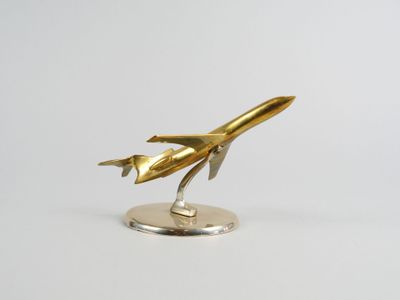 une maquette en métal doré représentant une navette spatiale, posée sur un socle